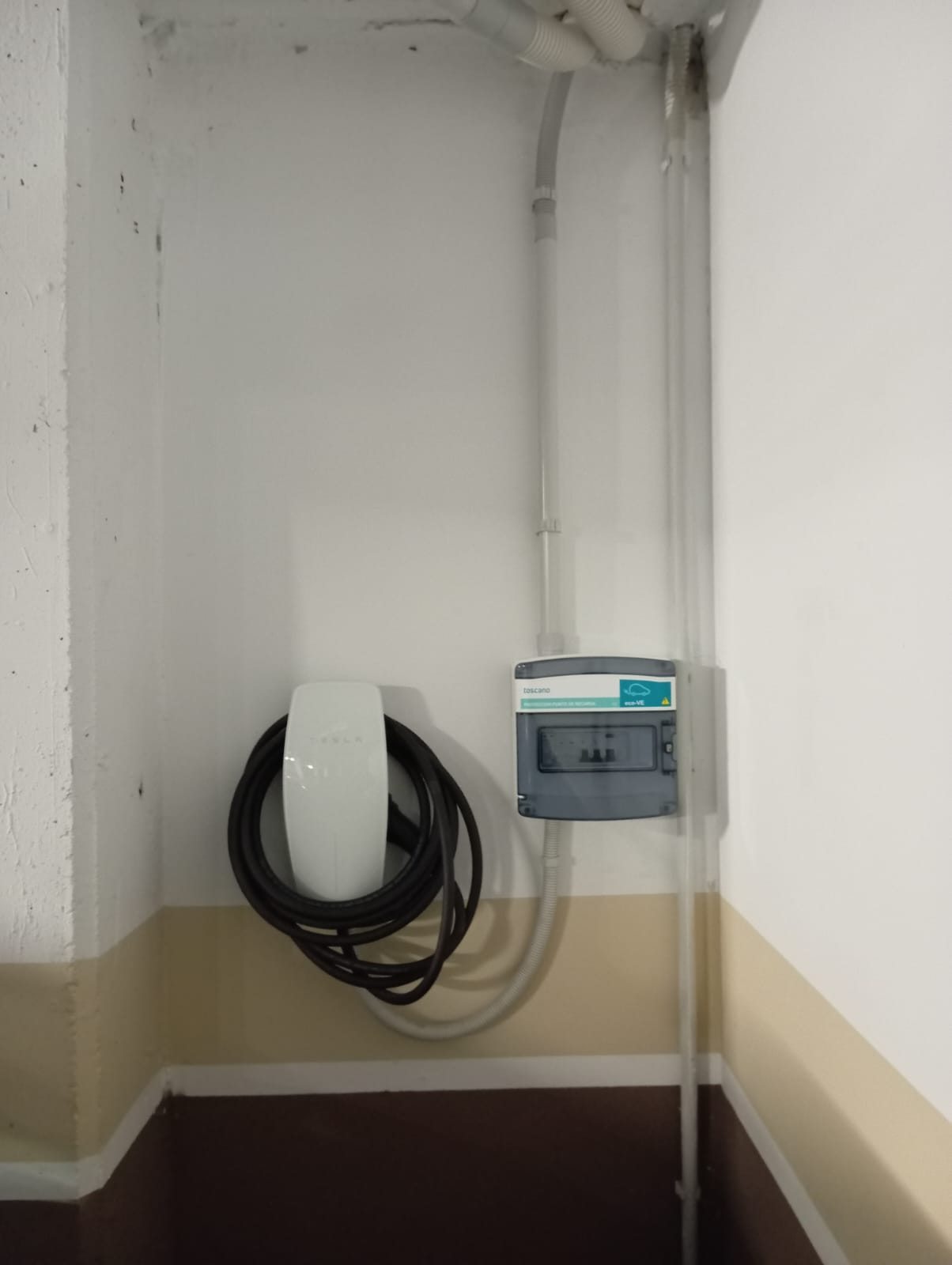 Cargador de coche eléctrico instalado en garaje con cuadro de protecciones